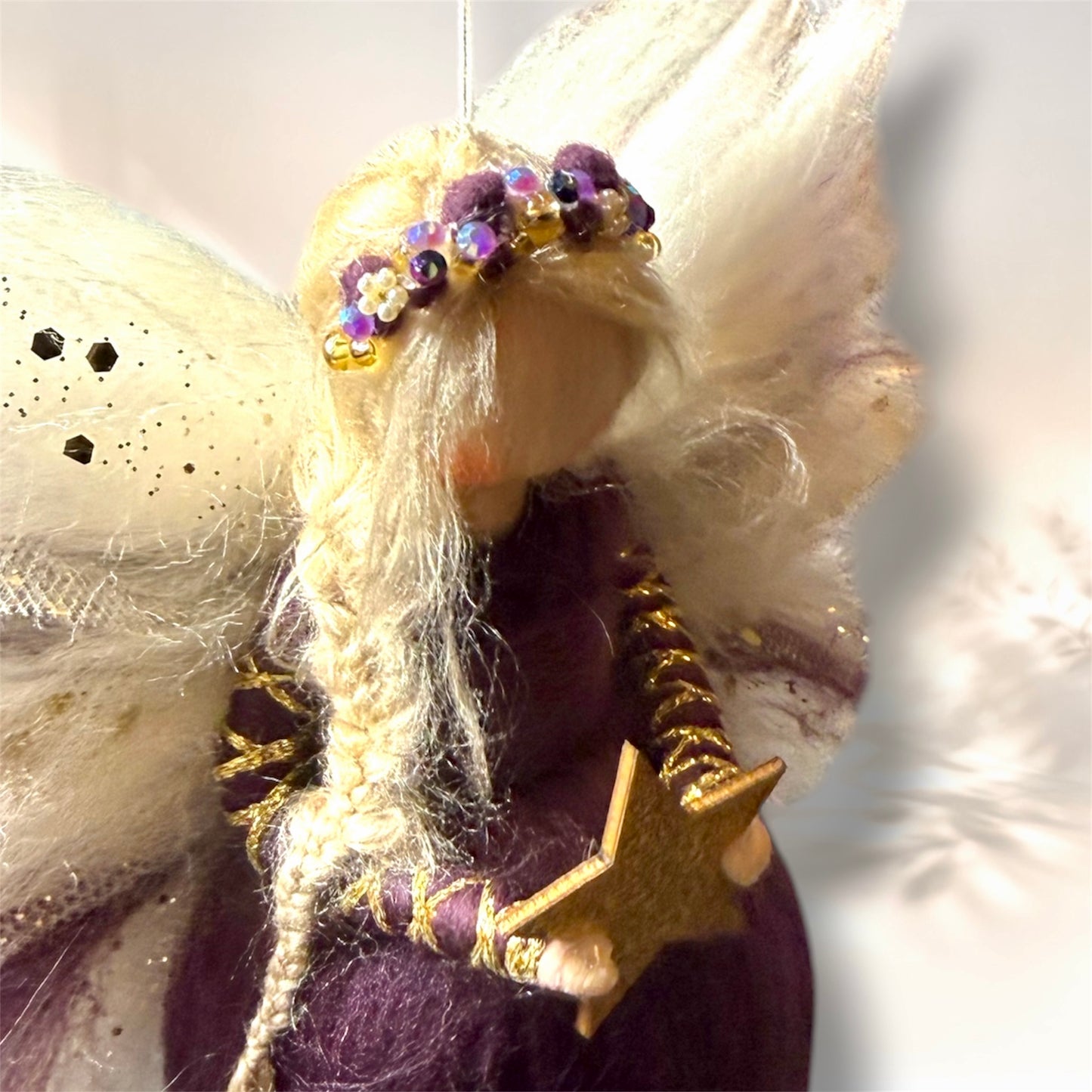 Detalje af uldengel med blomsterkrans i lilla og gyldne nuancer
