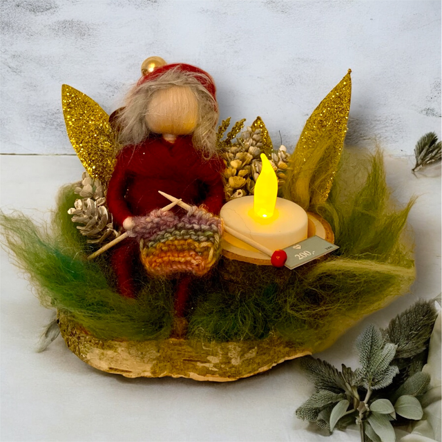 Juledekoration -  Nisse siddende ved Kogler og Guldblade med Strikketøj